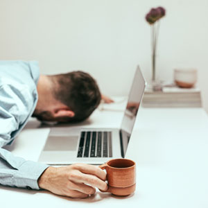 Tired Internet Marketer Dozing at His Laptop Face Down